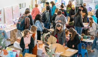 photo of people, tables and objects at an artist's market