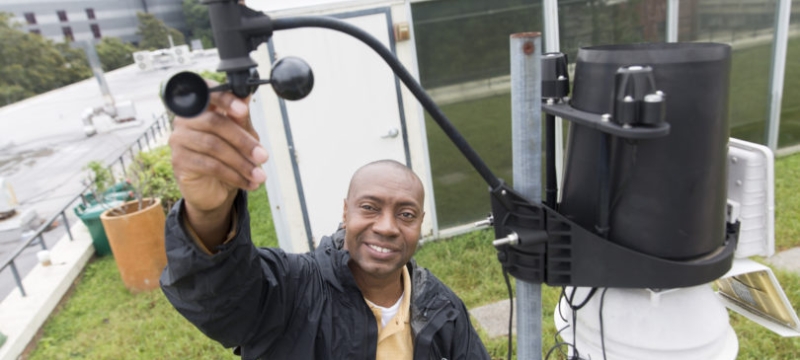 photo of man with wind gauge equipment, outside
