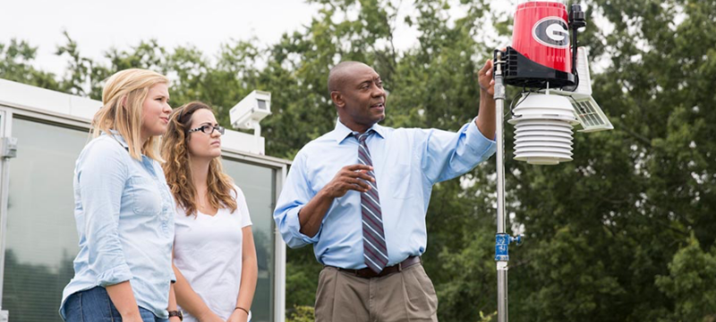 photo of man with student son rooftop weather station