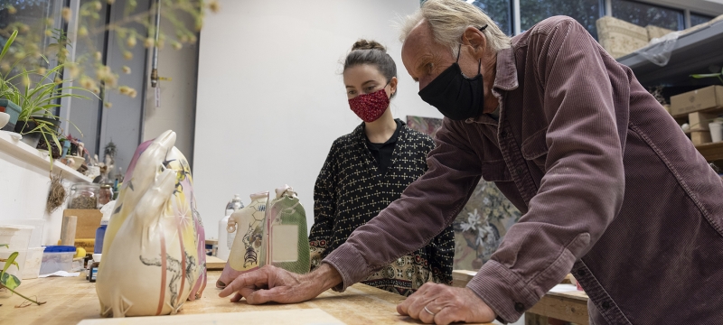 photo of two people in masks in art studio