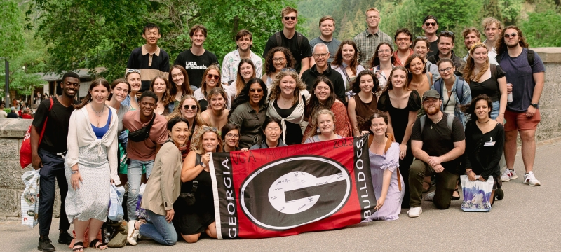 group photo of people, with super 'G' flag at center
