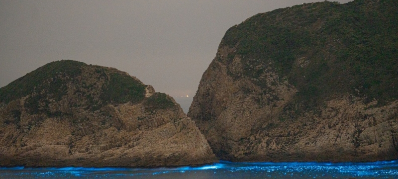 photo of land and sea with light blue shoreline