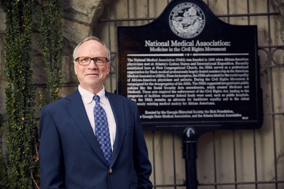 photo of man in front of historical marker