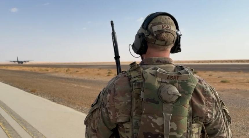 Alex Asay in military uniform standing on road in desert