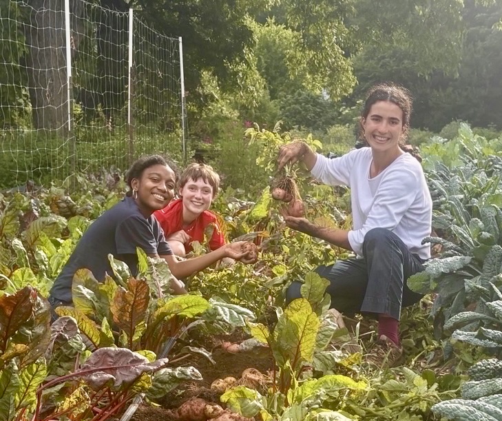 Maya Alandete and two students harvesting vegetables