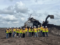 photo of people with backhoe in background, day