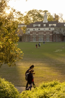 photo of students on quad near sunset, building in background
