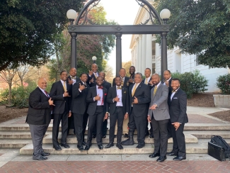 photo of men in suits in front of Arch, day