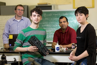 four people in a lab, with model
