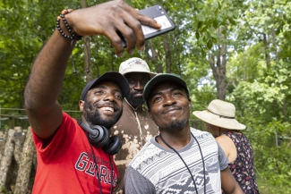 photo of three men taking a selfie, with trees, day