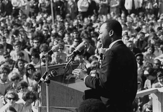black and white photo of man speaking before a crowd