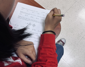 photo of person working match problems on paper with pencil