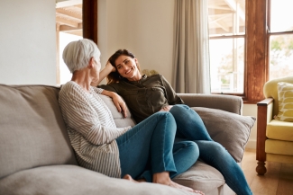 photo of two women talking on a couch