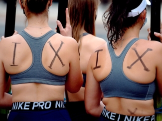 photo of women with I X written on their backs