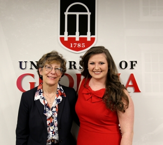 photo of two women standing in front of UGA logo