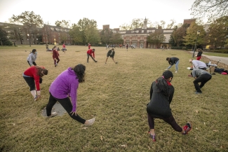 photo of a group of people, in a circle stretching 