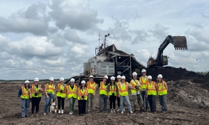 photo of people with backhoe in background, day