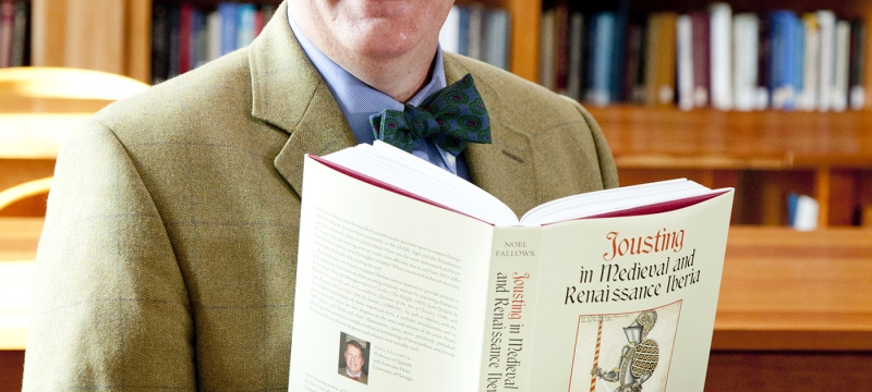 photo of man with book and book shelves