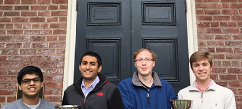 four students in front of Phi Kappa door