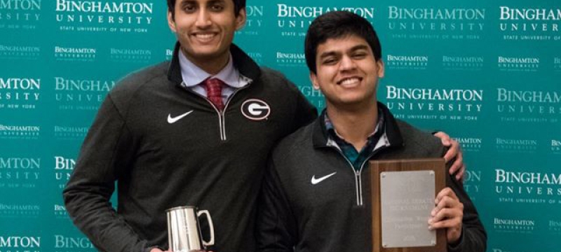 two students with plaque and cups