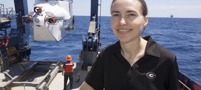 photo of woman aboard ship, ocean in background