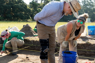 Professor Victor Thompson works with undergraduate student Katelyn Leka as they work on the excavation of their site.