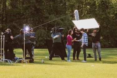 photo of people working on film set, outdoors, day