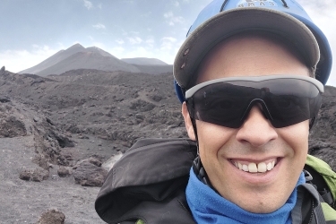 photo of man with volcanic mountain in background