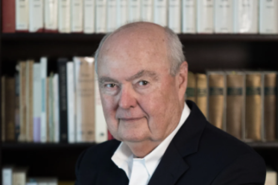 photo of man, bookshelves in background