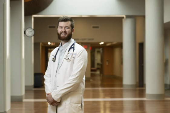 photo of man in white coat, in hallway