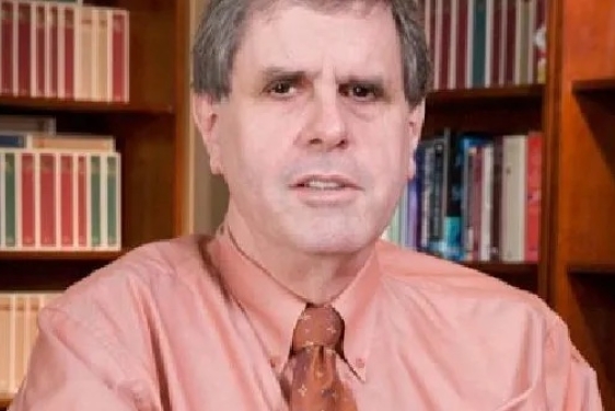 photo of man with books in background