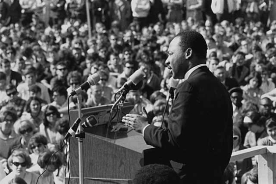 black and white photo of man speaking before a crowd