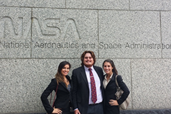 three students in front of NASA sign