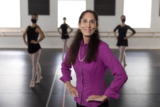 photo of woman in studio, with dancers in background