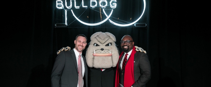 photo of two men with Hairy Dawg mascot and Neon sign
