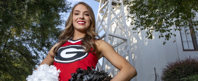 photo of cheerleader in front of the chapel bell