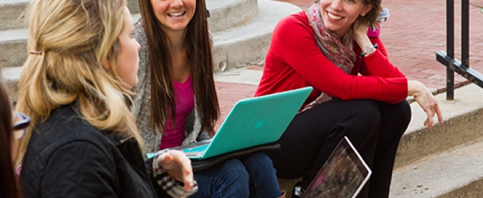 students on steps with computer