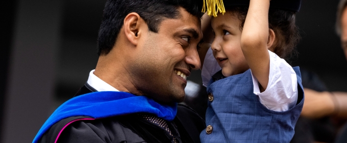 photo of man and child with cap and gown