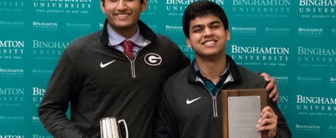 two students with plaque and cups