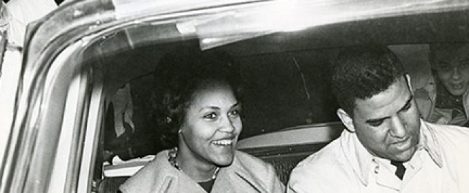 b/w photo of two people in a car, from outside