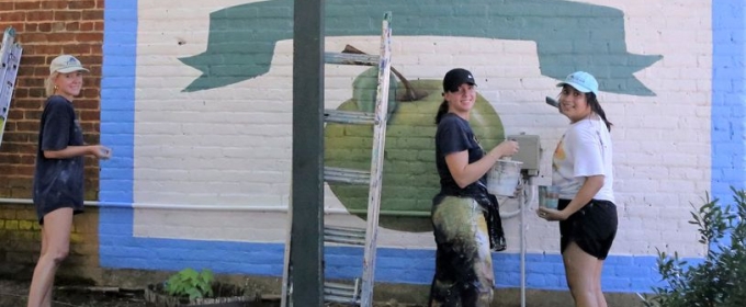 photo of three women painting a mural
