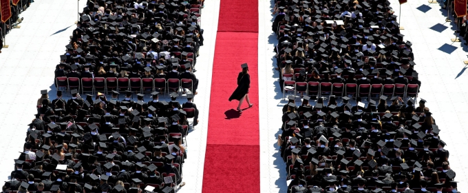 photo of student walking across red carpet at commencement