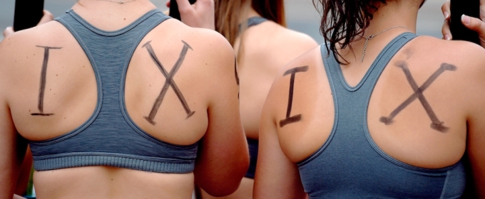 photo of women with I X written on their backs