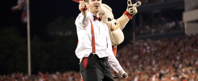 man at football game with mascot, crowd