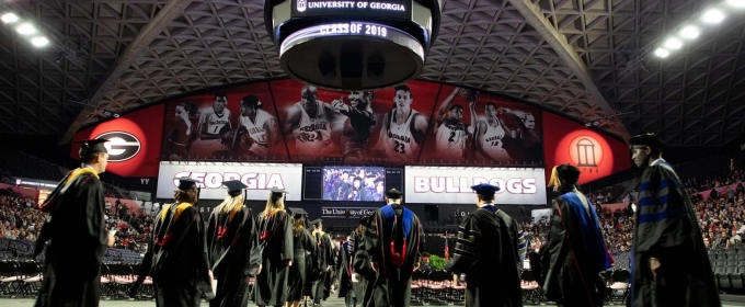 photo of people in caps and gowns inside the coliseum