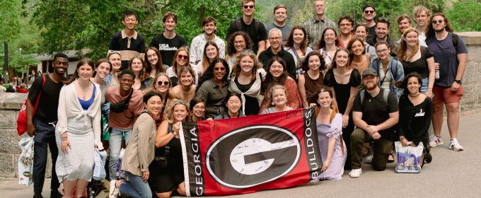 group photo of people, with super 'G' flag at center
