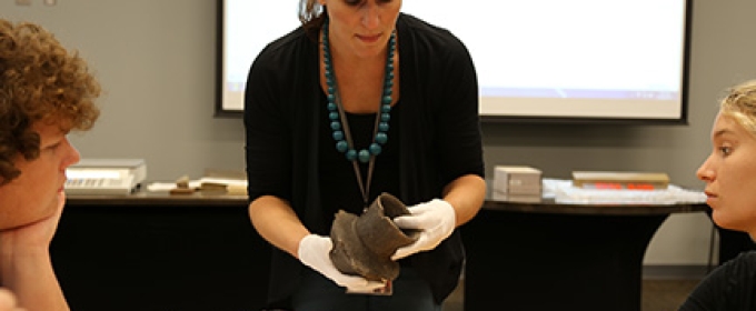 professor with artifact, students