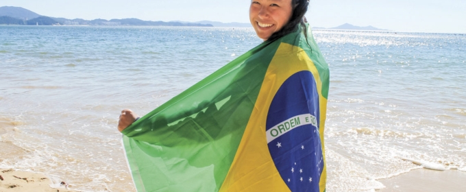 photo of woman on a beach with flag of Brazil
