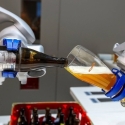 photo of two robot arms pouring beer into a glass